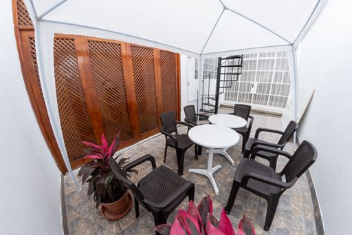 An outdoor patio set up with a table and chairs.