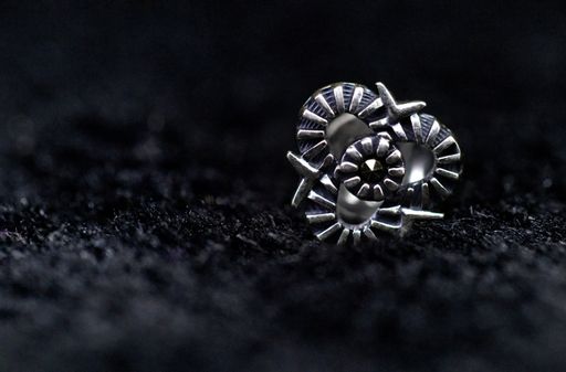 A closeup shot of antique silver earring on a black surface