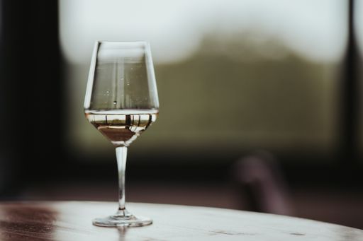 A closeup shot of a wine glass filled with white wine on the table