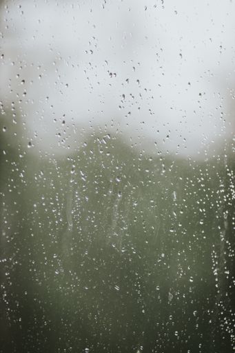 A closeup shot of a glass surface covered in raindrops