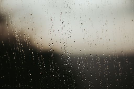A closeup shot of a glass surface covered in raindrops