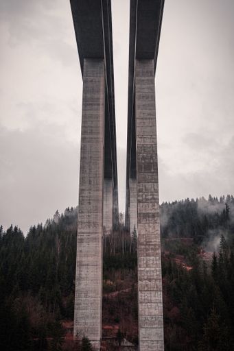 A stark architectural scene of a large bridge with several tall concrete pillars in Austria, Carinthia