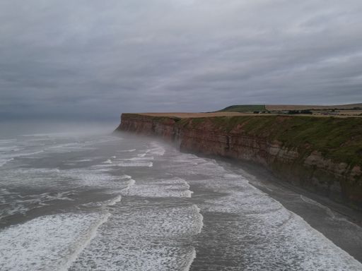 This image features an expansive, empty ocean on a stormy and foggy day, with choppy waters and a dramatic sky