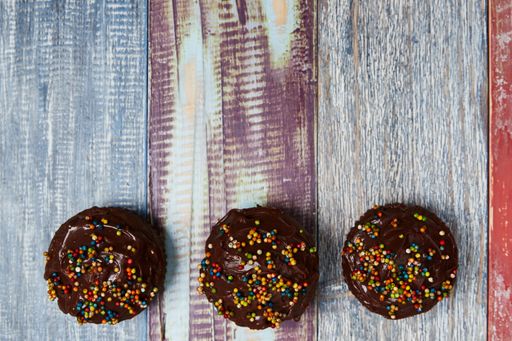 A top view of chocolate cupcakes on a wooden background