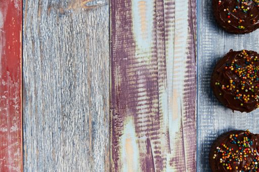 A top view of chocolate cupcakes on a wooden background