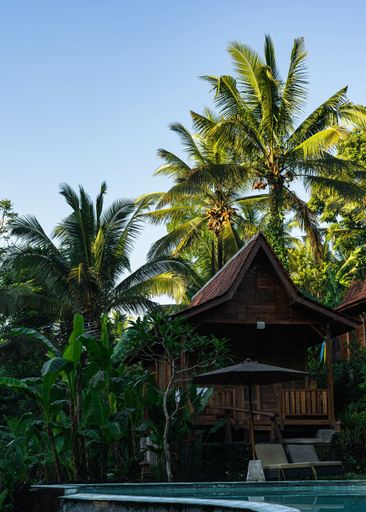 A vertical shot of a wooden house in tropical landscape on a sunny day