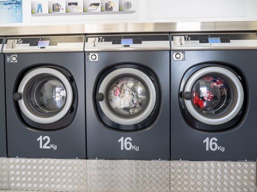 A row of washing machines in a public laundromat- concept for cleaning