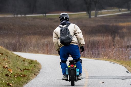 A man in a helmet rides a bicycle on the roadb