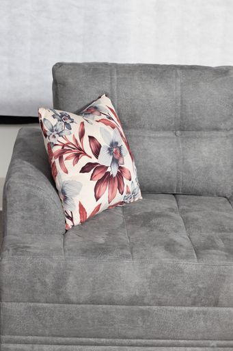A vertical shot of a pillow on a grey drape sofa in the living room