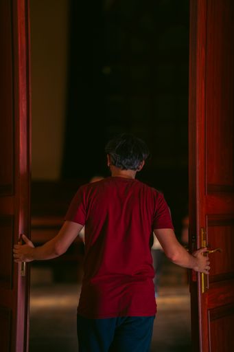 A vertical of a man opening the doors of a hall