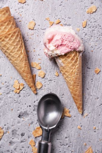 A top view of ice cream cones and a spoon on a grunge background