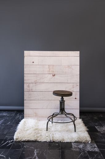 A stool against a wooden wall background in a studio
