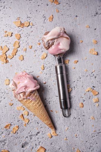 A top view of an ice cream cone and a spoon on a grunge background