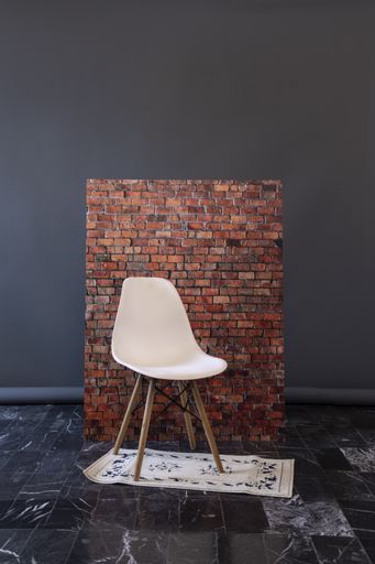 A chair against a brick wall background in a studio