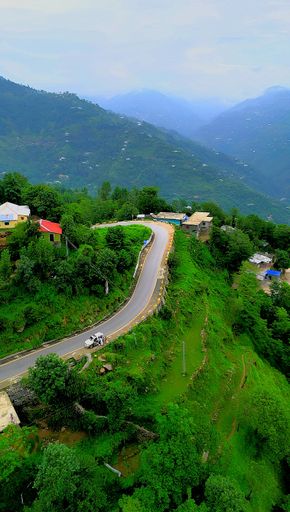 An aerial view of picturesque mountain road winding through lush green hills in Kashmir
