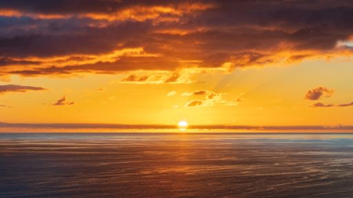 Sunset over Tasman sea at Piha beach, Auckland, New Zealand