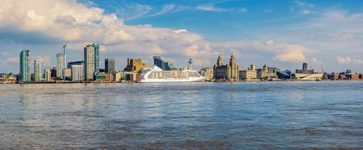 Liverpool city skyline looking across the Mersey with cruise ship alongside the quay and the famous liver birds.