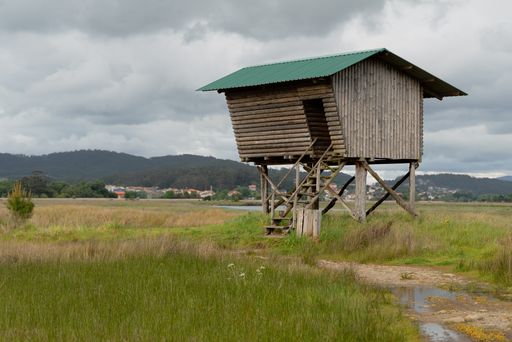 A wooden hut in a rural area on a cloudy day