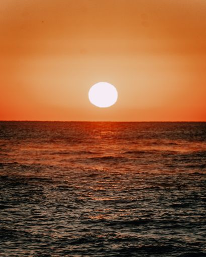 A vertical shot of the sea under the sunlight during a beautiful sunset in the evening