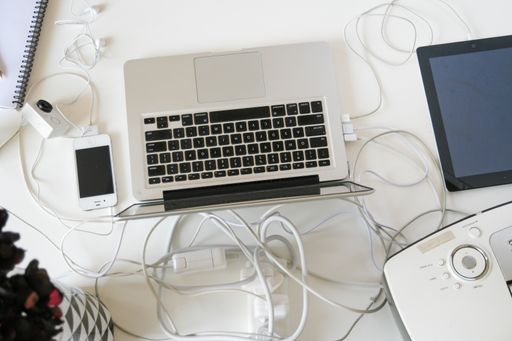 A top view of a laptop with a smartphone on a white surface