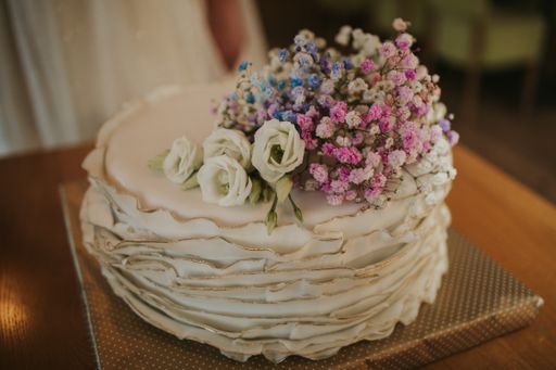 A small white wedding cake with natural flowers