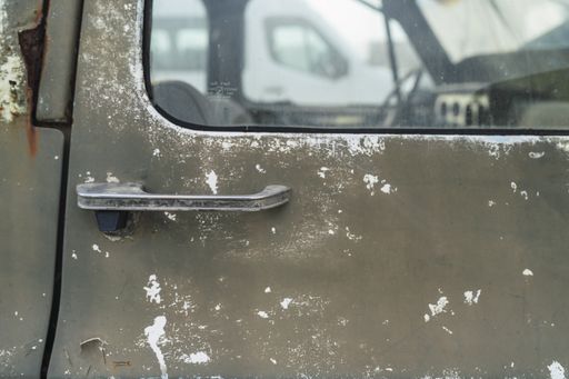A closeup of the door of an old abandoned pickup truck