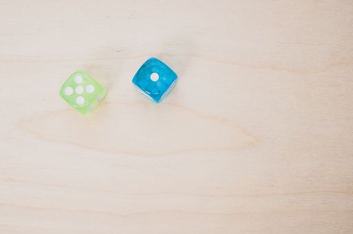 A top view of green and blue dice isolated on a wooden surface for a copy space