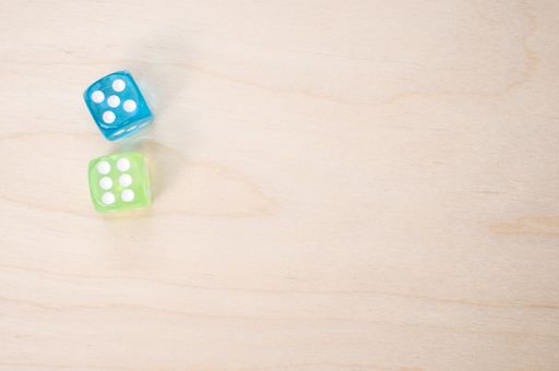 A top view of green and blue dice isolated on a wooden surface for a copy space