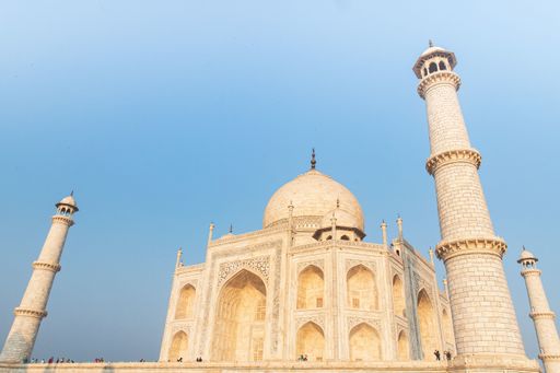 A low angle shot of the Taj Mahal mausoleum in India under a blue sky