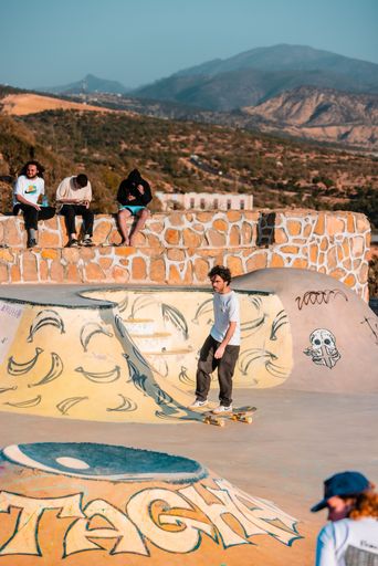 A closeup of a  young man on a skateboard  performing a trick on a ramp in Morocco