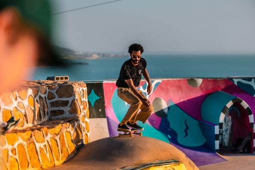 A closeup of a  young man on a skateboard  performing a trick on a ramp in Morocco