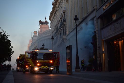Firefighters work to control a building fire on a street corner in Madrid.
