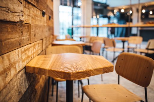 A close up view of empty wooden coffee shop tables