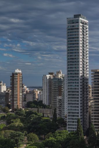 A vertical shot of a tall beautiful buildings of Rosario city in Argentina during sunset