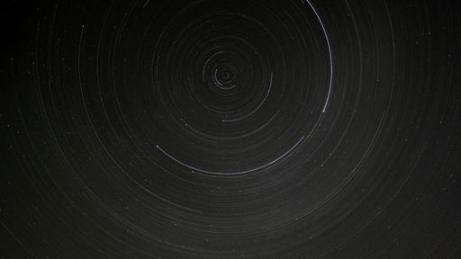 A long exposure with rotating stars seemingly chasing or racing each other in circles.