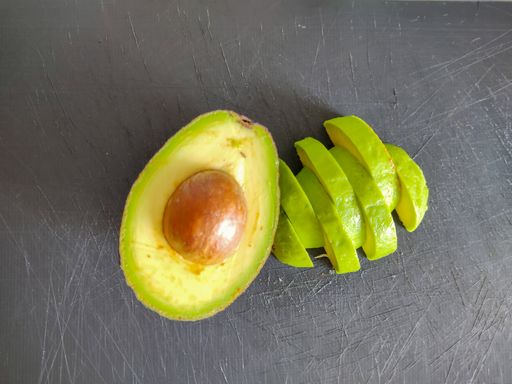 A top view of sliced avocado on a black surface