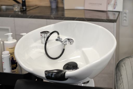 Hair wash sink for washing hair in beauty salon or Barber shop, shampoos, towels. Hairdresser stylist work space. Hairdressing bowl.