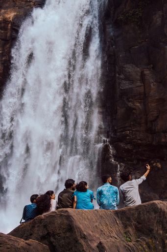 group of friends taking selfie in a waterfall