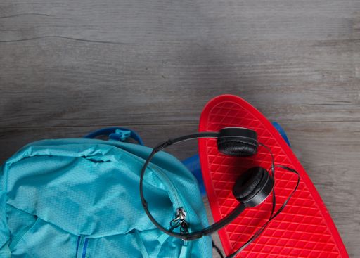 A skateboard with headphones and a bag - alternative means of transportation concept