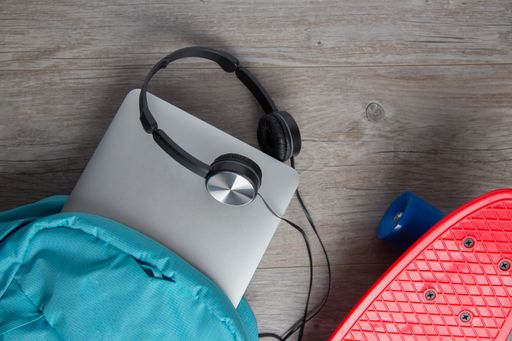 A skateboard with headphones and a bag - alternative means of transportation concept