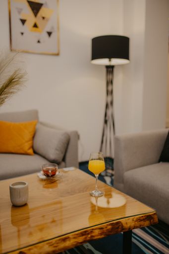 A vertical shot of a hot tea and a glass of juice on a reflecting table in a comfortable house