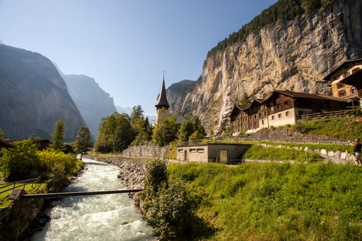 A scenic view of the Lauterbrunnen Valley in the Swiss Alps with wooden buildings surrounded by trees