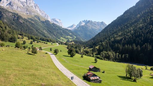 A scenic view of the Lauterbrunnen Valley in the Swiss Alps with wooden buildings surrounded by trees