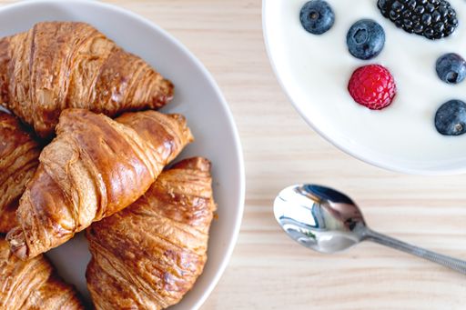 A top view of delicious croissants and yogurt with berries for breakfast