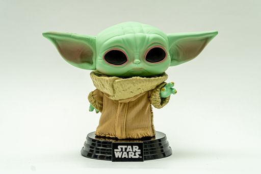 Isolated shot on white background, of a figure of the Grogu character known as baby yoda, from The Mandalorian series of Star Wars of the funko pop