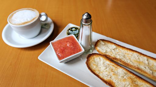 A typical Spanish breakfast toast with olive oil, salt, and tomato and a cup of coffee