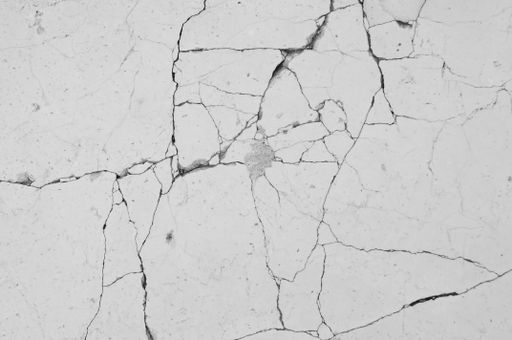 A closeup black and white shot of a cracked wall forming a background