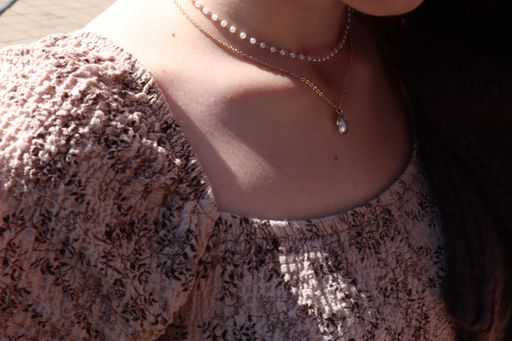 Close-up image of a female with a necklace and pearls