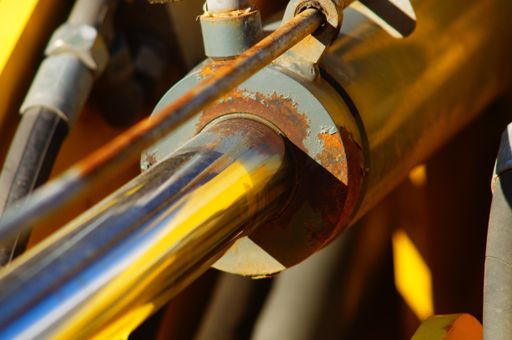 Close-up of a hydraulic cylinder of a construction machine. A small excavator.