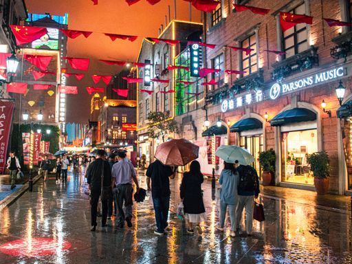 The several people walking in the rain at night in Wuhan, China.